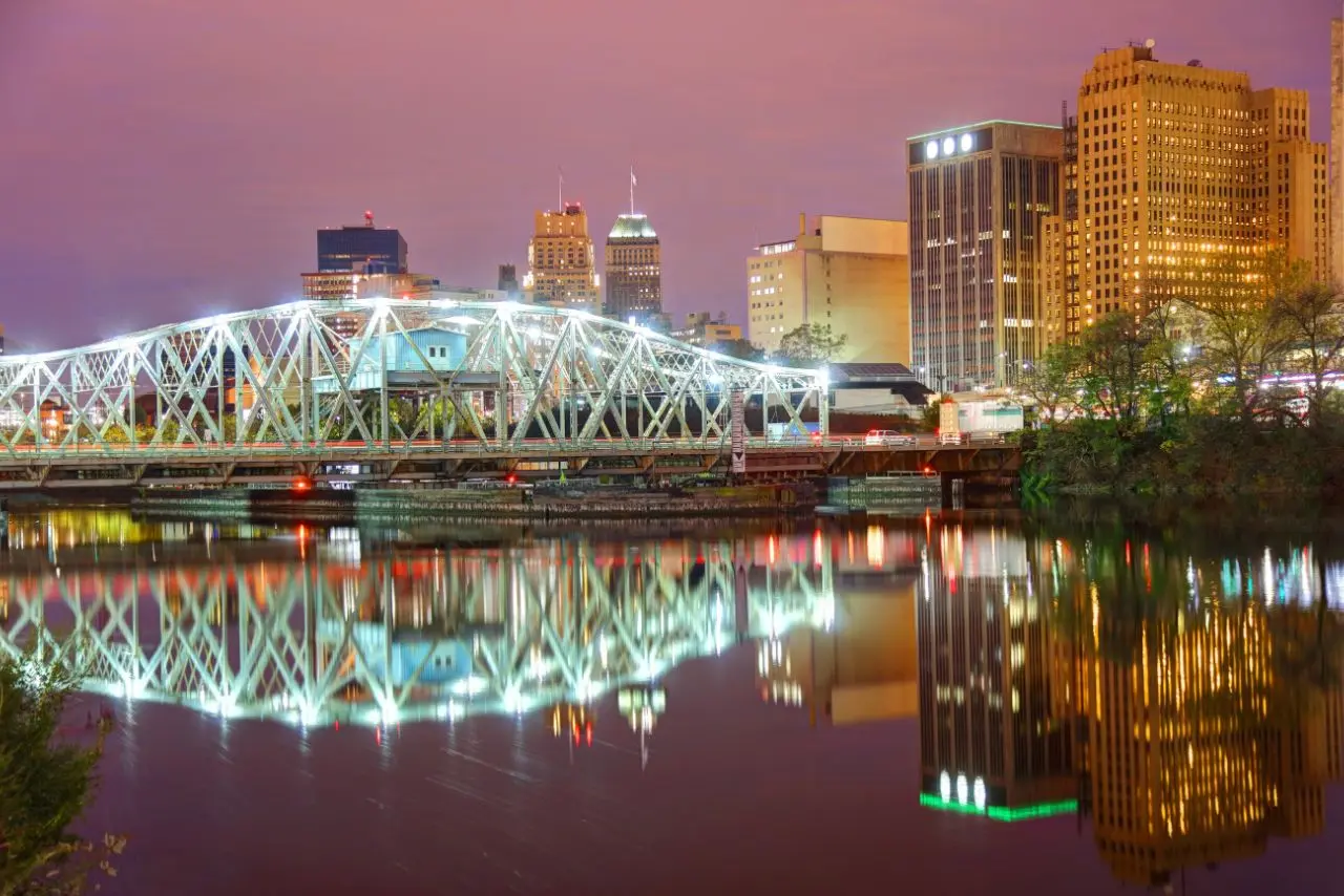 Night view of Newark and lit bridge reflecting on the river, representing commercial cleaning services New Jersey.