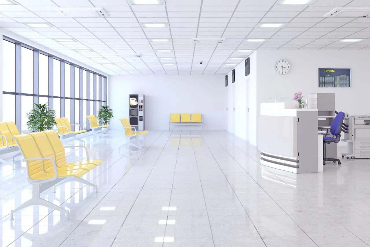 Shiny hospital waiting area with clean yellow chairs and polished floors maintained through expert floor cleaning services.