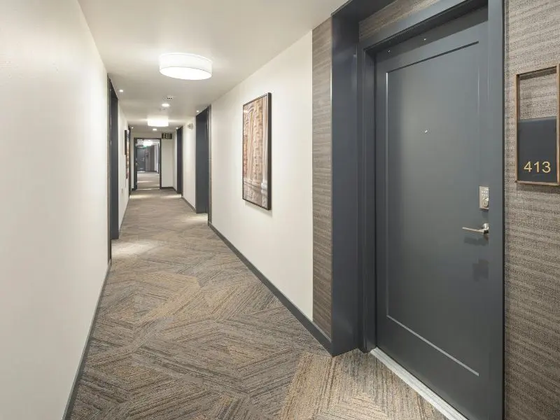 Clean apartment hallway with patterned carpet, showing results of professional commercial carpet cleaning services.