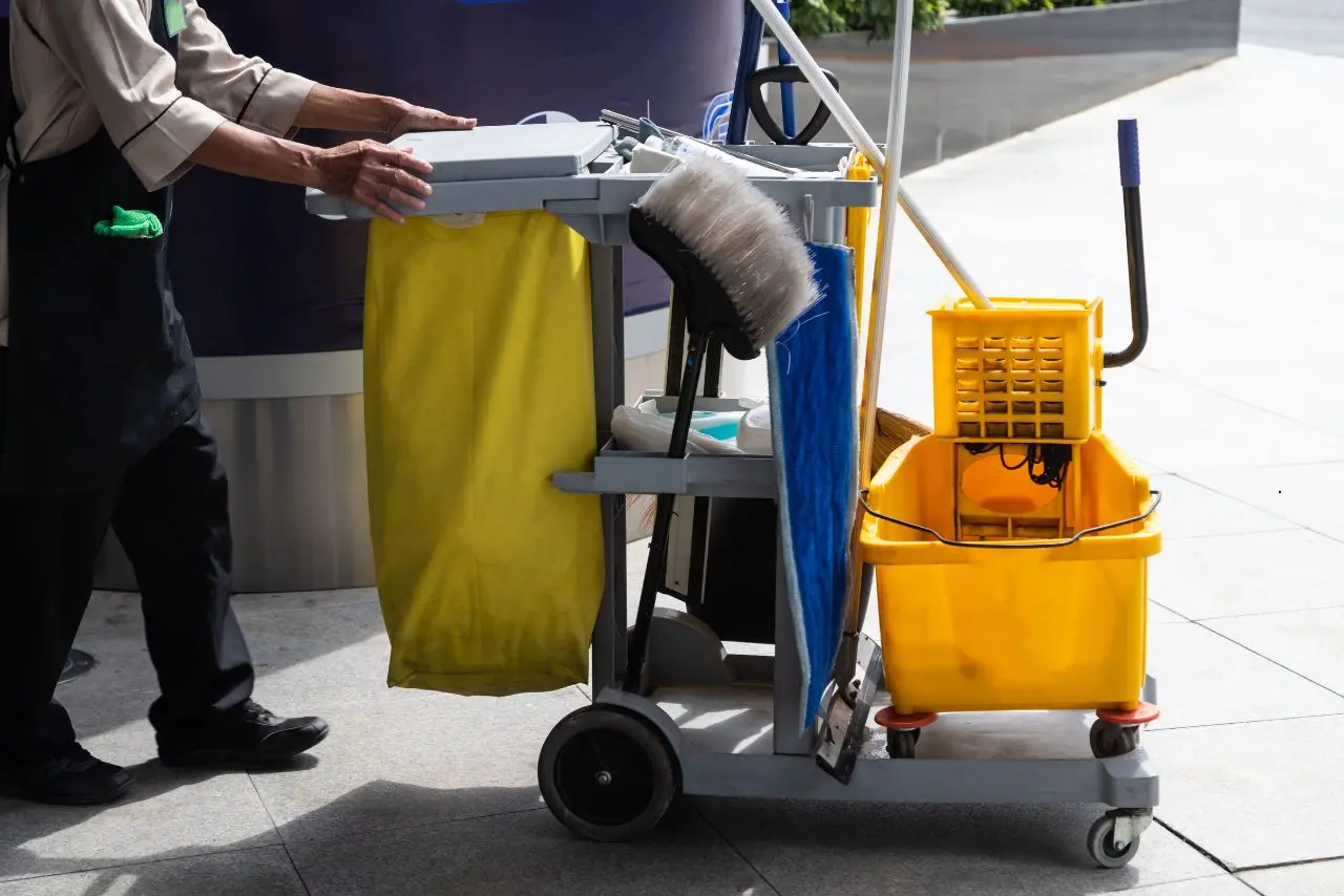 Janitor with a full cleaning cart and mop bucket, ready to deliver professional janitorial services across commercial spaces in New Jersey.