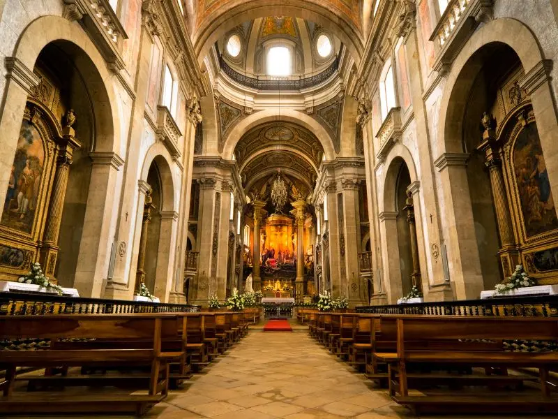 Elegant historic church interior with polished floors, wooden pews, and a golden main altar cleaned by church cleaning services.
