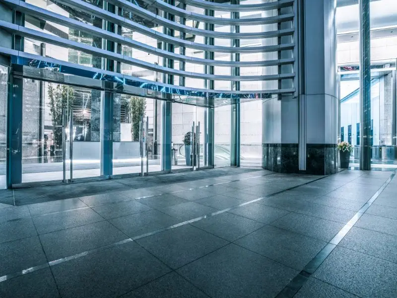 Spacious, spotless office lobby with glass walls and tile flooring maintained by commercial cleaning services.