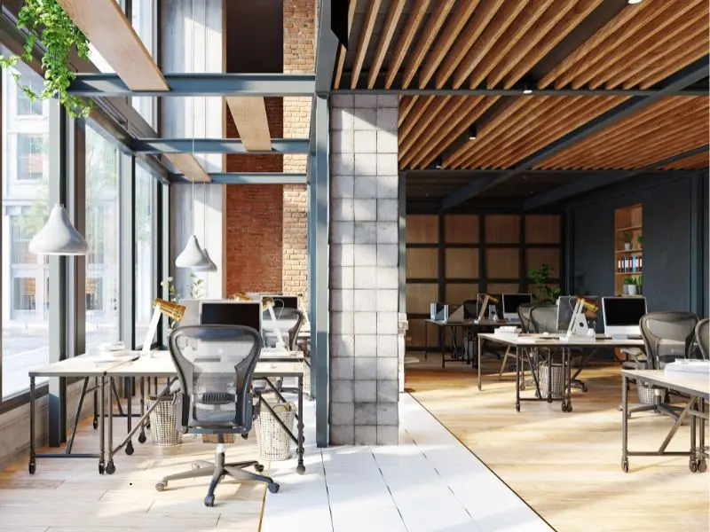 Modern professional office space with large windows, clean desks, and natural lighting in an organized layout.