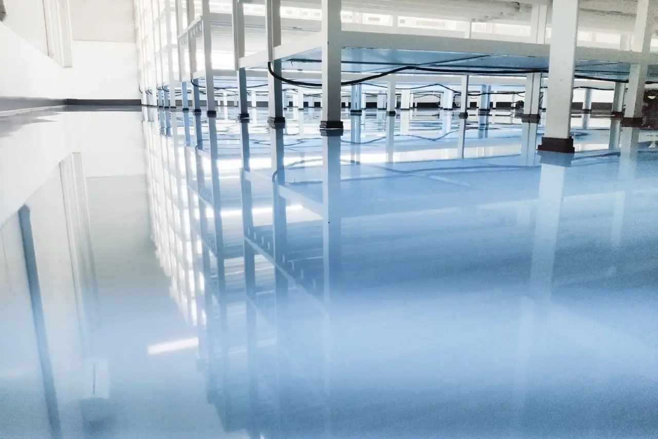 Bright industrial space with shiny floors cleaned through specialty cleaning services, reflecting shelves and lights