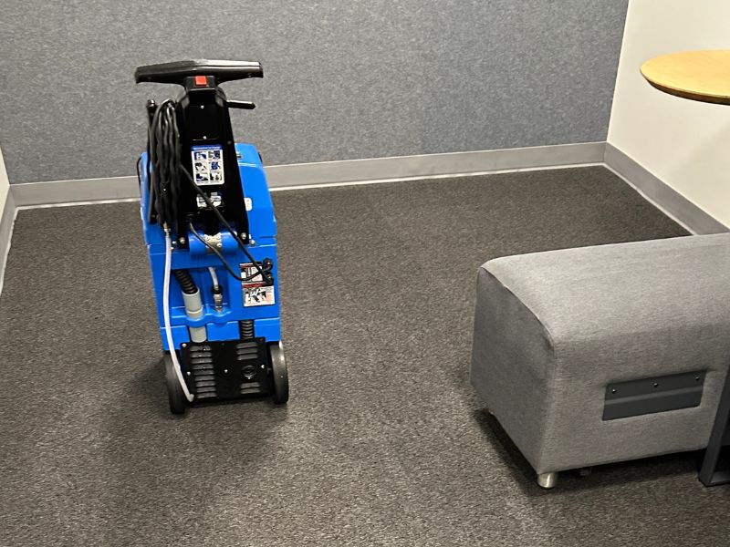 Advanced encapsulation carpet cleaning machine positioned on commercial carpet flooring in a modern office waiting area.
